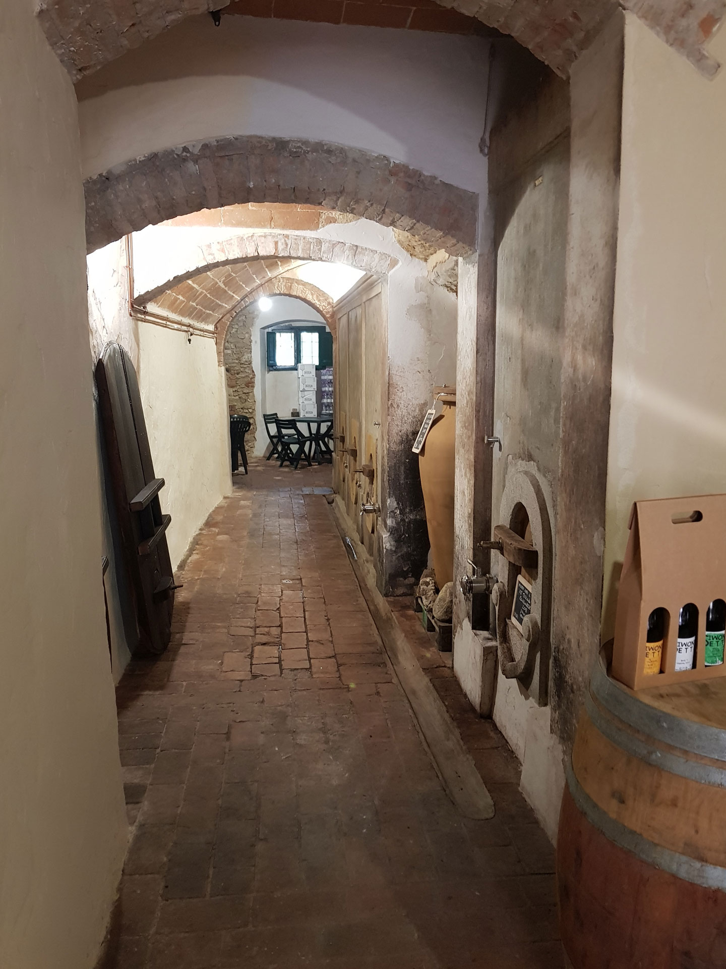 Il corridoio a volte in mattoni, l'anfora, le botti